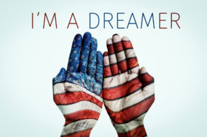the hands of a man put together patterned as the flag of the Uni DACA Lawyer